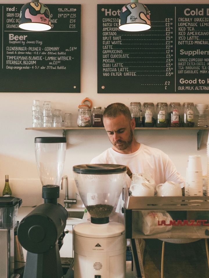 Barista making coffee behind a café counter